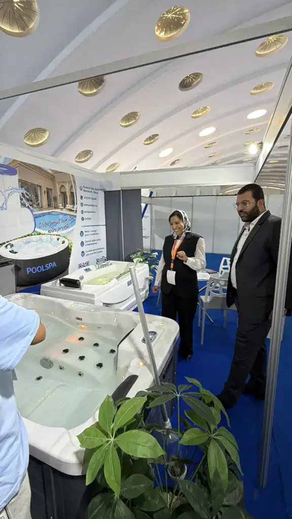 PoolSPA à Africa Pool & Spa Expo 2026 : le bien-être à la rencontre des professionnels 4 Baignoire de balnéothérapie blanche à jets avec une plante verte au premier plan, sur le stand PoolSPA.