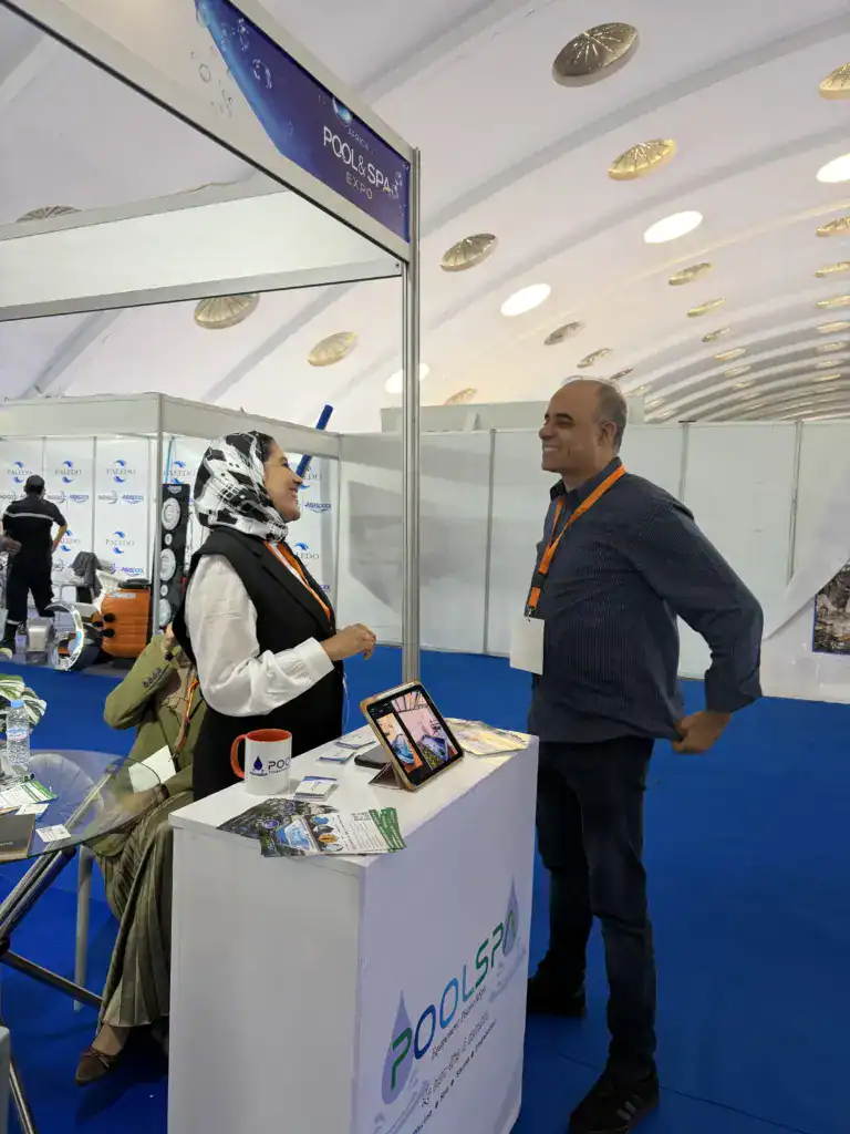 PoolSPA à Africa Pool & Spa Expo 2026 : le bien-être à la rencontre des professionnels 15 Échange au comptoir du stand PoolSPA, avec une tablette, des brochures et une tasse rouge posées sur le comptoir blanc.