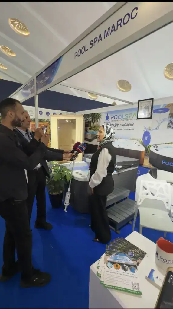 PoolSPA à Africa Pool & Spa Expo 2026 : le bien-être à la rencontre des professionnels 17 Coin du stand PoolSPA sous le panneau Pool Spa Maroc, avec des visiteurs en conversation et des brochures sur le comptoir.