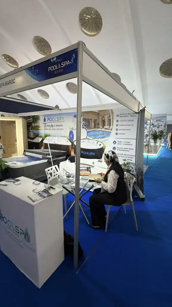 PoolSPA à Africa Pool & Spa Expo 2026 : le bien-être à la rencontre des professionnels 2 Stand PoolSPA sous le bandeau Pool & Spa Expo, avec un spa, un sauna et une personne assise à une table en verre.